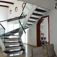 Moderné, dizajnové schodisko s bielymi schodnicami a skleným zábradlím.