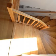 Celodrevený obklad železobetónového schodiska. Vzhľadom na to, že zábradlie je prerušené ramenom schodiska sú na stenách použité madlá. Prírodný dub.
